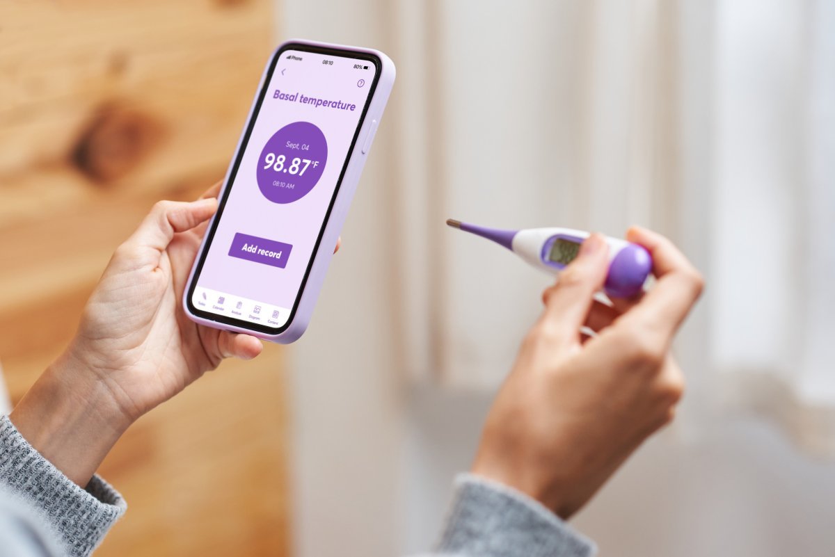 Woman using digital thermometer to measure metabolism and body temperature
